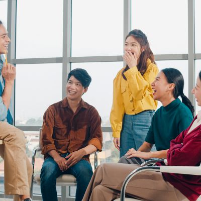 Group of young college students in smart casual wear on campus. Friends brainstorming meeting talking and discussing work ideas new design project in modern office. Coworker teamwork, startup concept.